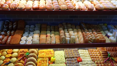 Abundant rows of diverse bread loaves and buns on bakery shelves. A frontal view Stockbeeldmateriaal 336339393