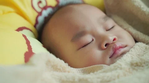 ฺaby is lying on a yellow bed. Stock Footage 114131438