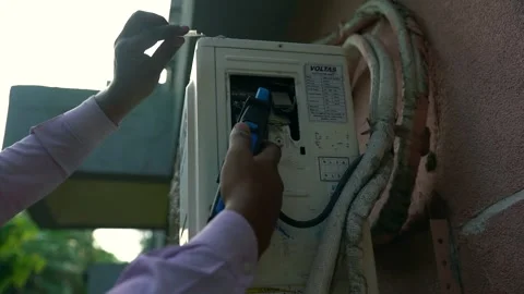 Ac engineer cheking power with digital clamp meter Stock Footage 246422612
