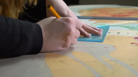 Academic Cartography: PhD Candidate Deciphers Maps in University Lab Stock Footage 266232574