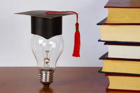Academic hat on a light bulb. Stock Photos