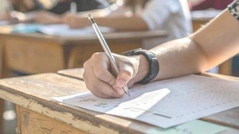 Academic knowledge test with student hands writing answers during an exam Stock Photos