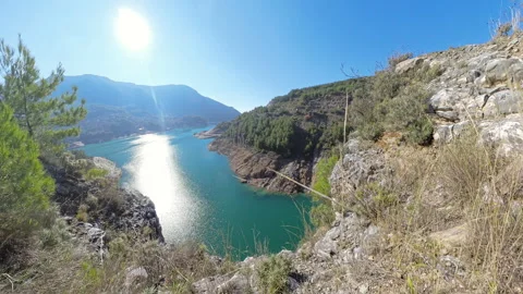 Accelerated Perspective of a Cliffside Path Plummeting Toward a Distant Lake Stock Footage 297608648