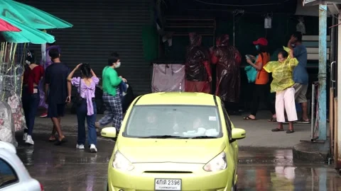 Accelerated traffic on a street where an elderly woman slowly puts on a raincoat Stock Footage 244941102