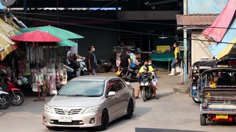 Accelerated video of traffic at a small intersection next to a market Stock Footage 235425555