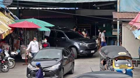 Accelerated video of traffic at a small intersection next to a market Stock Footage 240314582