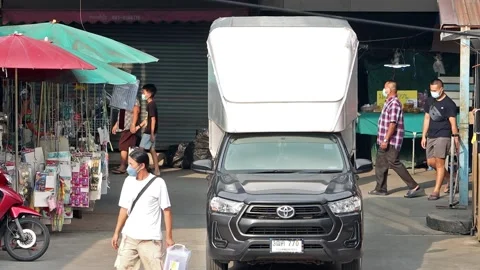 Accelerated video of traffic at a small intersection next to a market Stock Footage 243365541