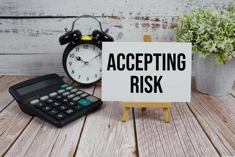 Accepting Risk text with alarm clock and calculator on wooden background Foto stock