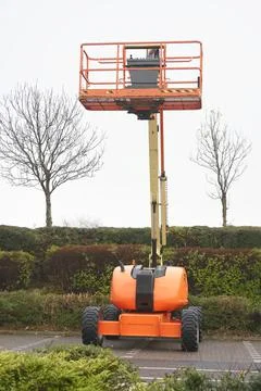 Access platform equipment powered high in sky in orange for high working Stock Photos