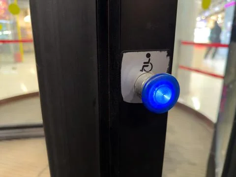 Accessibility features at building entrance. Button to slow down revolving .. Stock Photos