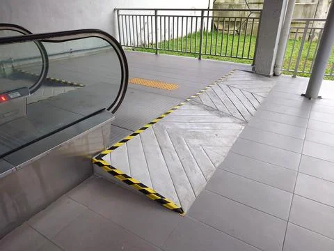 Accessibility ramp at end of escalator at a public building. Stock Photos