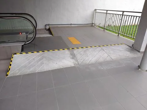 Accessibility ramp at end of escalator at a public building. Stock Photos