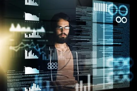 Accessing important information. a young computer programmer working on source Stock Photos