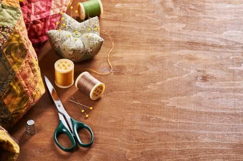 Accessories for patchwork on a quilt on a wood background Stock-Fotos