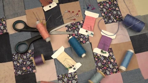Accessories for patchwork sewing lie on a patchwork textile  Stock Footage 260639870