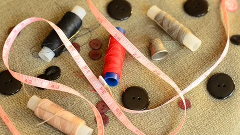 Accessories for sewing: needles, threads, buttons, a thimble and a tape measure Stock Footage 102675986