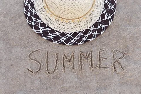 Accessory straw hat on the beach on the sand on the beach with the text summ Stock Photos