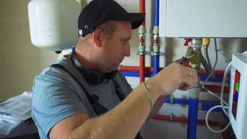 Accident, breakdown in heating system. Plumber is repairing boiler. Maintenance Stock-Footage 319506860