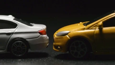 ACCIDENT: Close up of toy model car crashes to white toy car (slow motion) Stock Footage 72915741