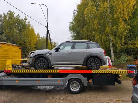 Accident-damaged Mini Cooper on flatbed tow truck Stock Photos
