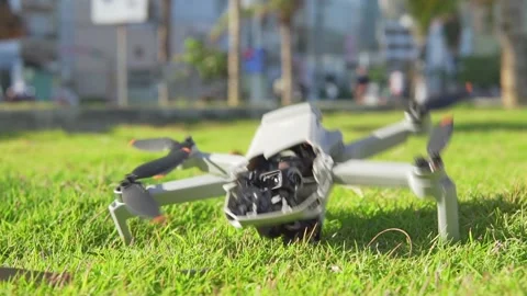 Accident with a drone. Damaged quadcopter falls on green grass Stock Footage 168289470