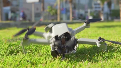 Accident with a drone. Damaged quadcopter falls on green grass Stock Footage 243472611