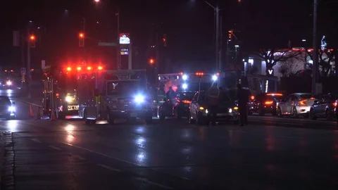 Accident at night in city intersection with ambulance and police at crash scene Stock Footage