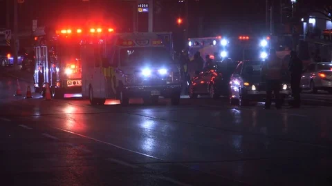 Accident at night in city intersection with ambulance and police at crash scene Видео