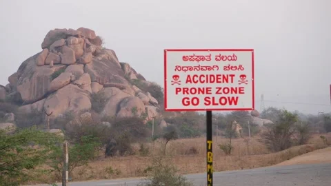 Accident prone zone go slow sign board along the road Stock Footage 151962668