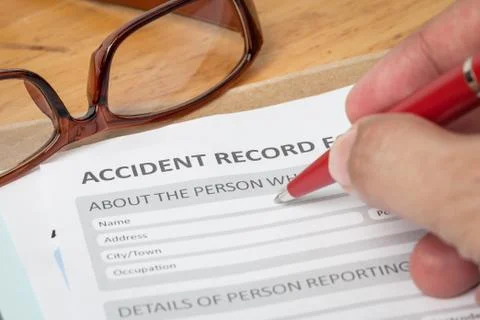 Accident report application form and human hand with pen on brown envelope an Stock-Fotos