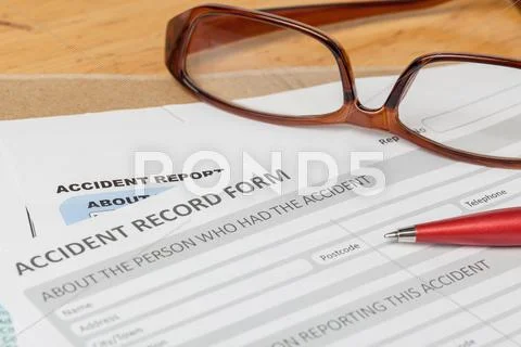 Accident Report Application Form And Pen On Brown Envelope And Eyeglass, Busi