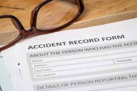 Accident report application form on brown envelope and eyeglass, business ins Stock Photos