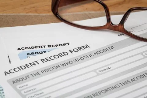 Accident report application form on brown envelope and eyeglass, business ins Foto stock