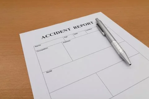 Accident report form with pen on table Stock Photos