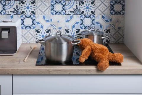 Accident risk in the kitchen with teddy bear plush toy on the stove Stock-Fotos