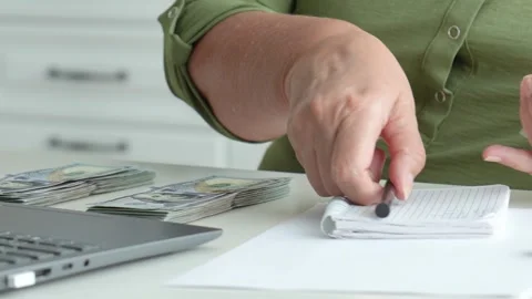 Accountant counting and writing down money on a notepad Stock Footage 316150505