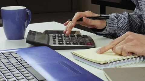 Accountant or manager making calculations and taking notes in notebook at work. Stock Footage 101700746