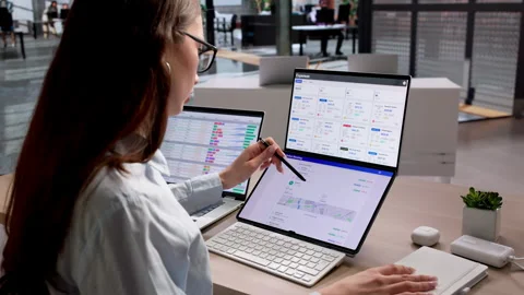 Accountant Reviewing Multiple Financial Reports On Laptop Vídeo Stock 335455164
