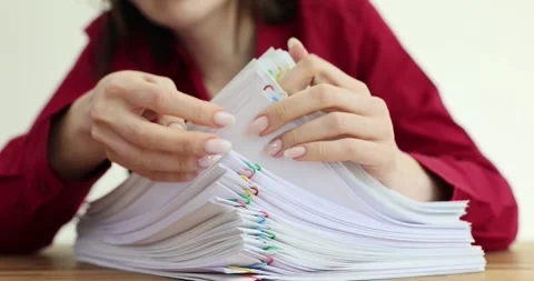 Accountant sorts stack of papers with multicolored paper clips on table Stock Footage 287680105