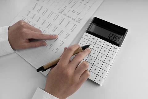 Accountant using a calculator and points her finger at the numbers in the f.. Stock Photos
