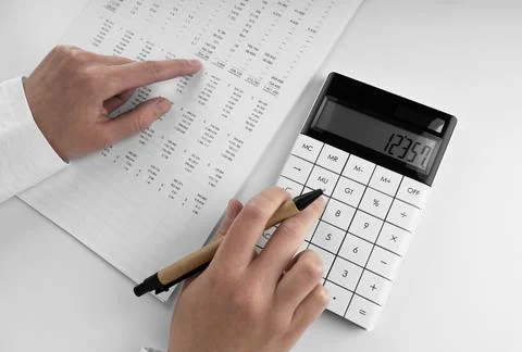 Accountant using a calculator and points her finger at the numbers in the f.. Stock Photos