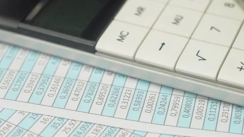 Accountant using calculator to calculate in spreadsheet tax refund at office Stock Footage 303377138