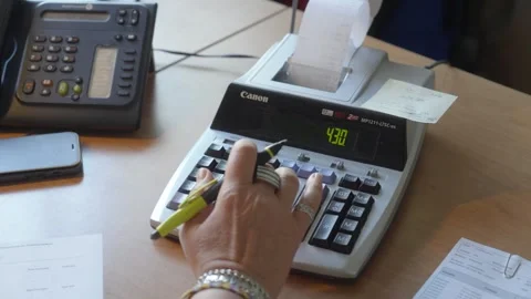 Accountant using a printing calculator for financial data. Close-up of hand Stock Footage 335445214
