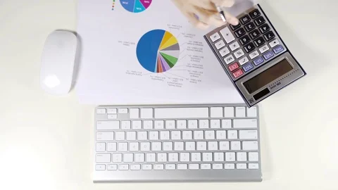 Accountant working with calculator and graph document on white desk in office Stock Footage 78604308