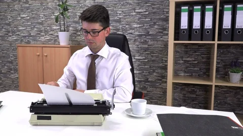 Accountant writes on a typewriter at a table in the workplace Stock Footage 115878710
