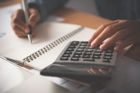 The accountant's hand is using the calculator. For cost analysis Profit and l Stock Photos