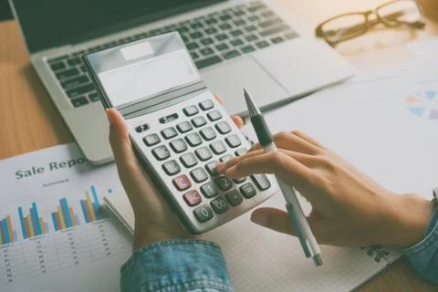 The accountant's hand is using the calculator. For cost analysis Profit and l Stock Photos