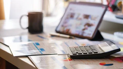 Accounting work space with digital tablet, calculator, financial graph and .. Stock Photos