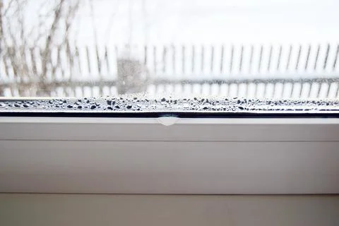 Accumulation of water on a plastic white window in winter, condensation Stock Photos