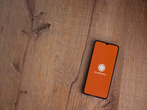 AccuWeather app launch screen with logo on the display of a black mobile smar Stock Photos